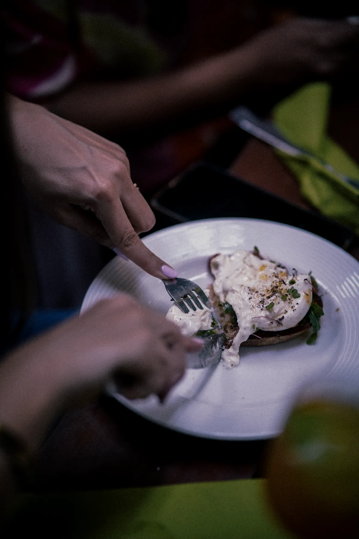 Hands cutting into a plated dish